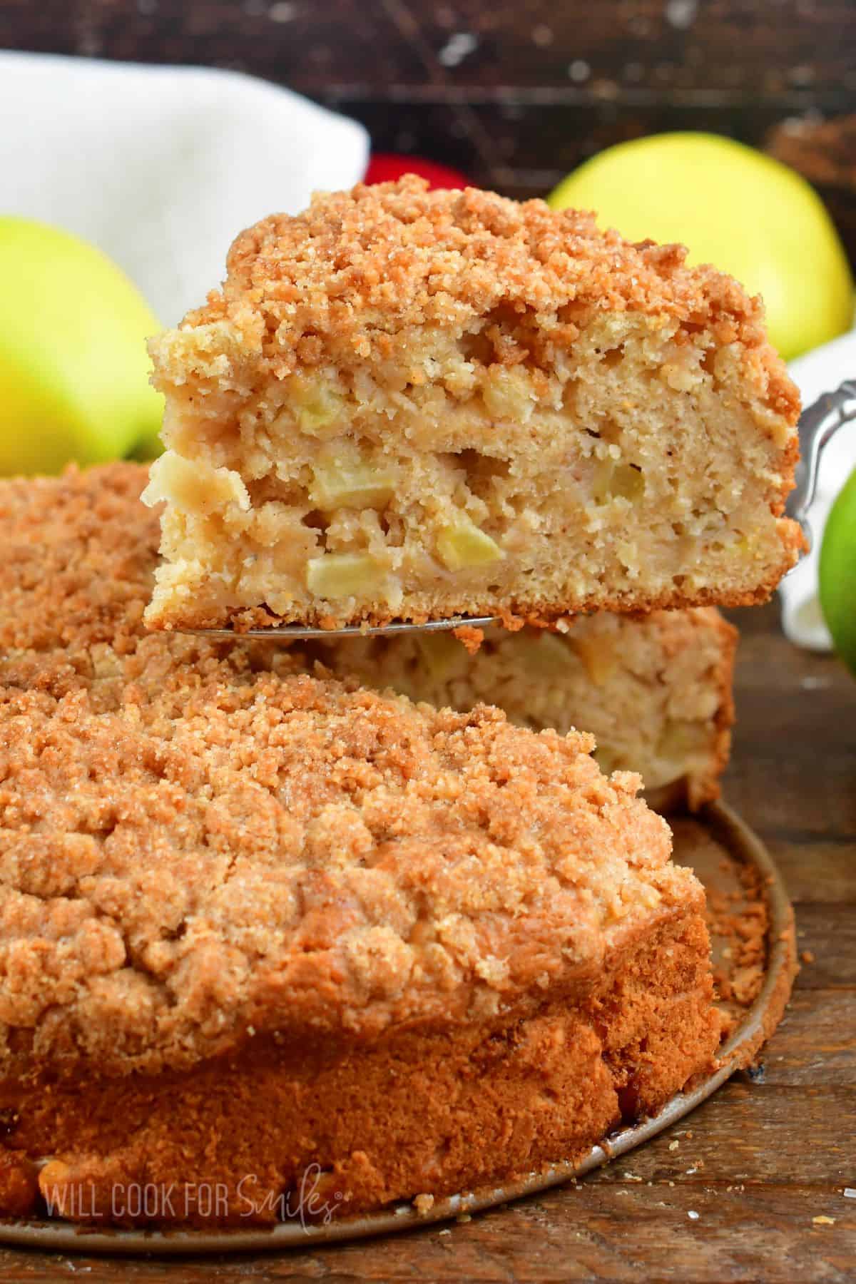 pulling out a slice of the apple cake from the whole.