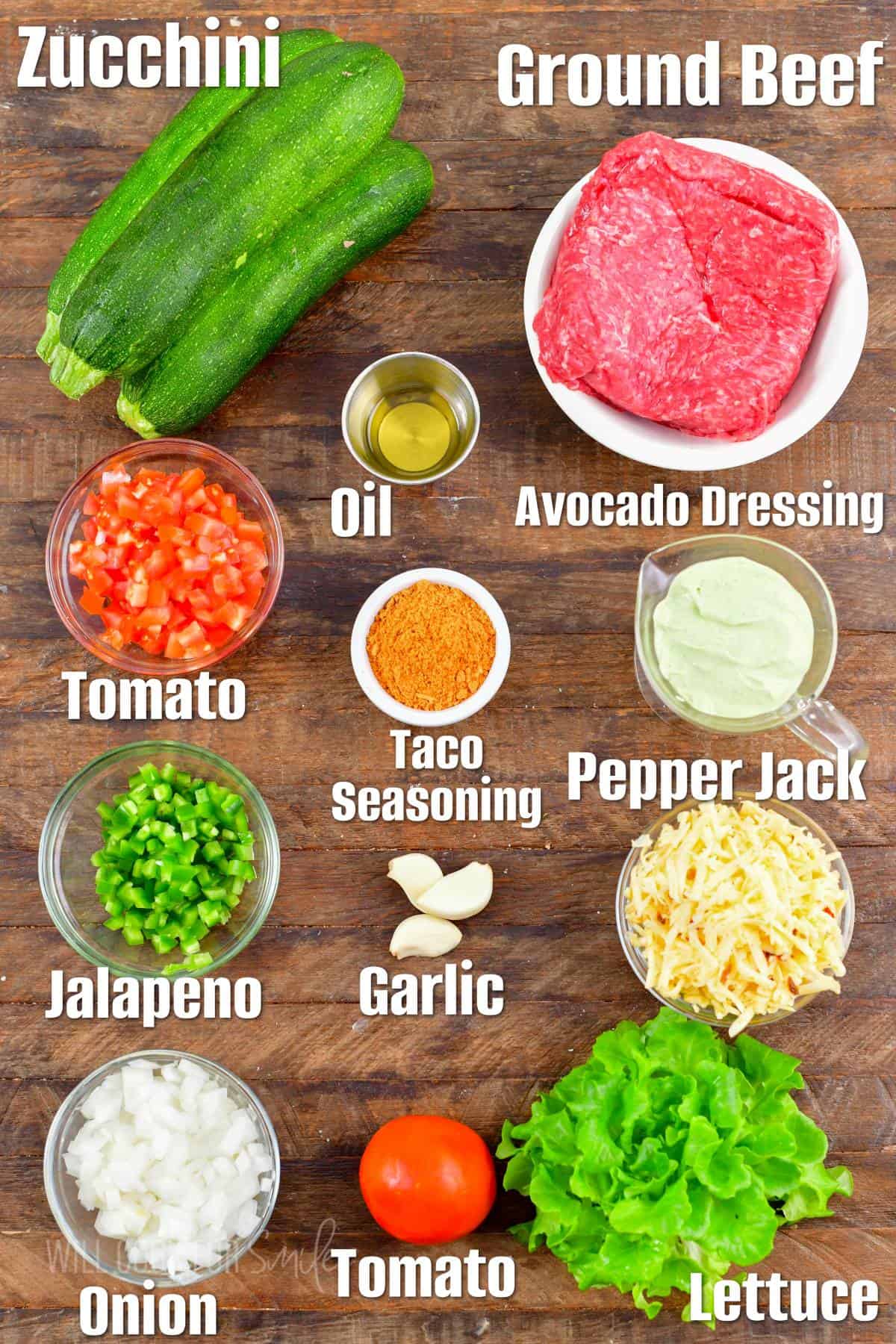 The ingredients for taco stuffed zucchini boats are placed on a wooden surface.