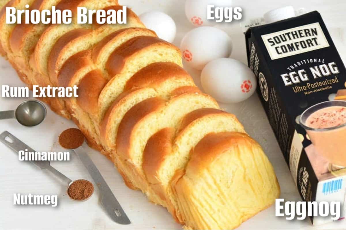 Labeled ingredients to make eggnog French toast on a white surface.