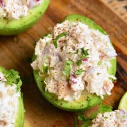 avocado half stuffed with chicken salad and some more surrounding it.