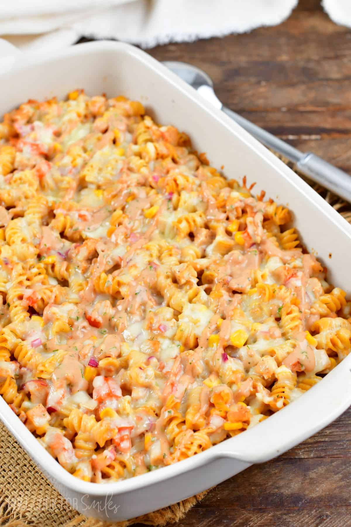 BBQ Ranch Chicken pasta bake in a casserole dish on a wood surface.