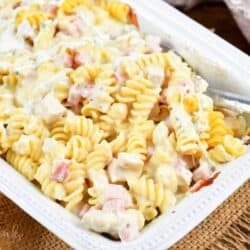 Chicken Cordon bleu chicken casserole in a baking pan with a metal spoon.