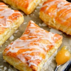 lemon cheesecake hand pies on a parchment paper lined baking sheet.