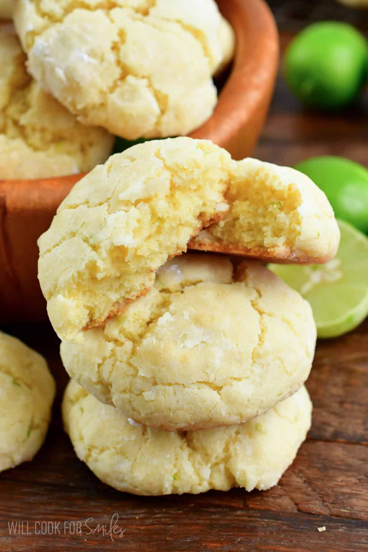 A stack of coconut cream cheese cookies with the top cookie cut in half.