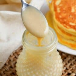 spooning out some of the coconut syrup out of the jar.