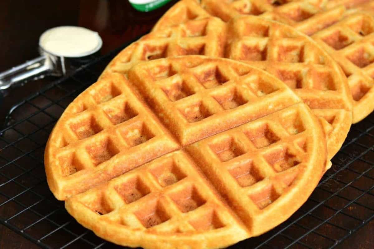 Three waffles cooked and lined up on a wire rack.