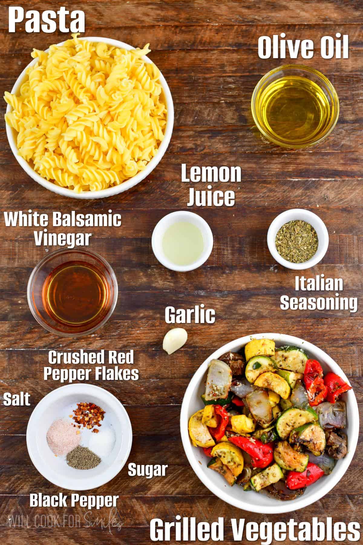 Labeled ingredients for Grilled Vegetables Pasta Salad on a wood surface.