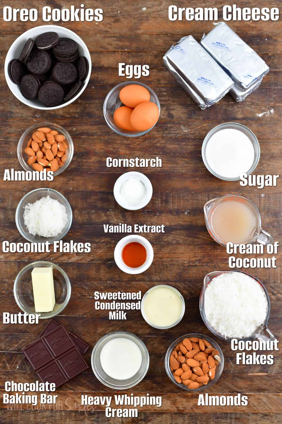 labeled ingredients to make an almond joy cheesecake on wooden background.