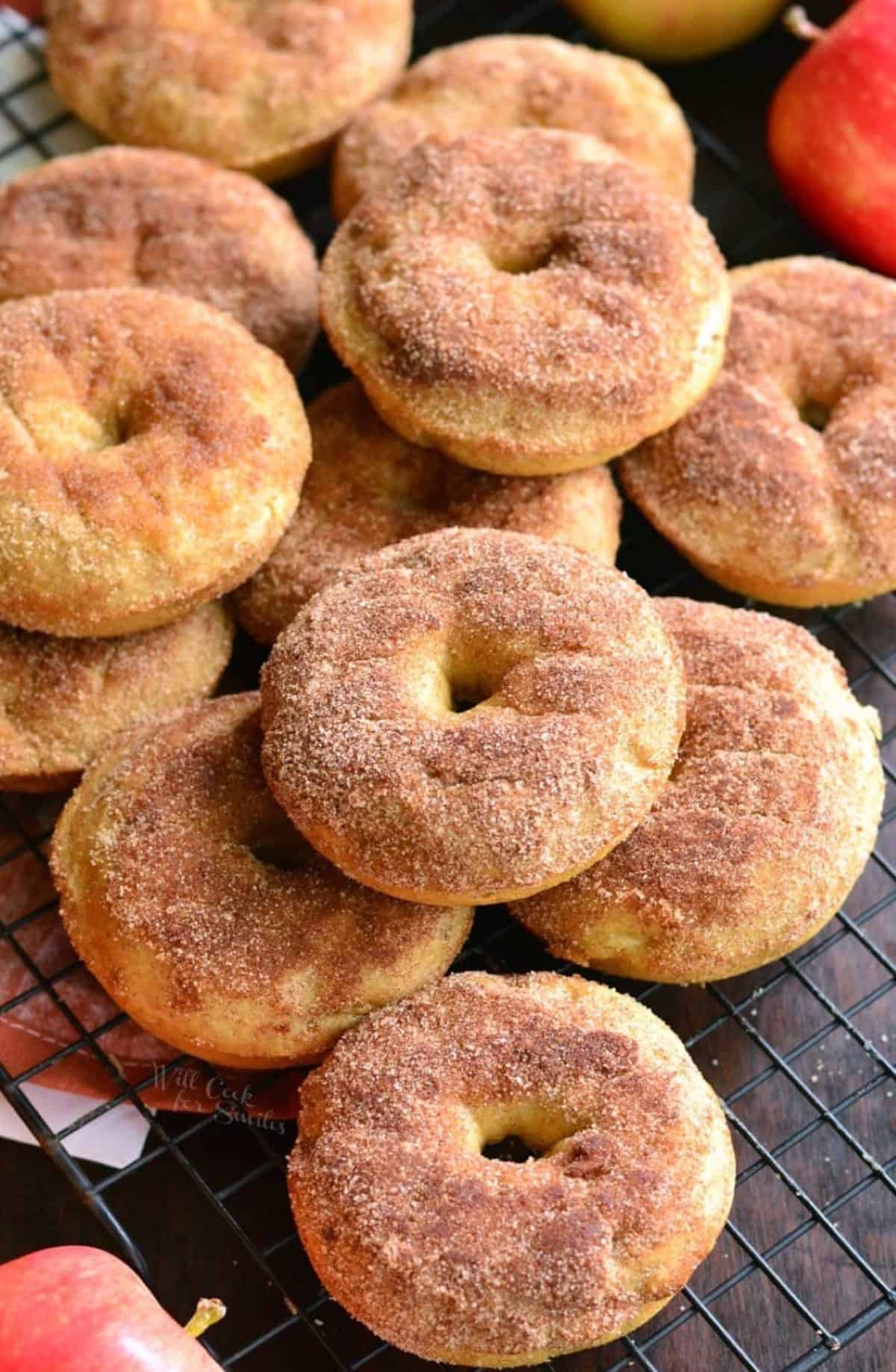 apple pie donuts piled up on a wire rack.
