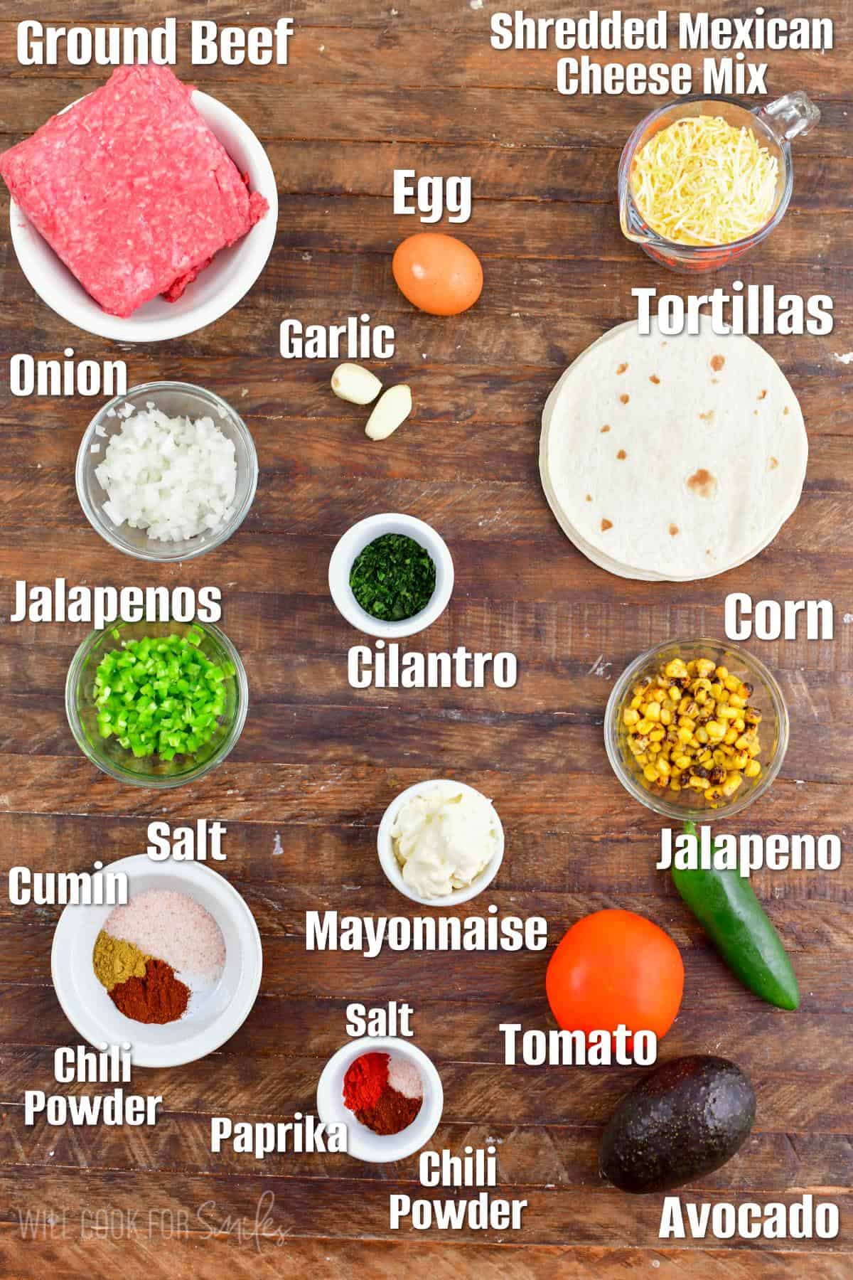 Labeled ingredients for quesadilla burger on a wood surface.