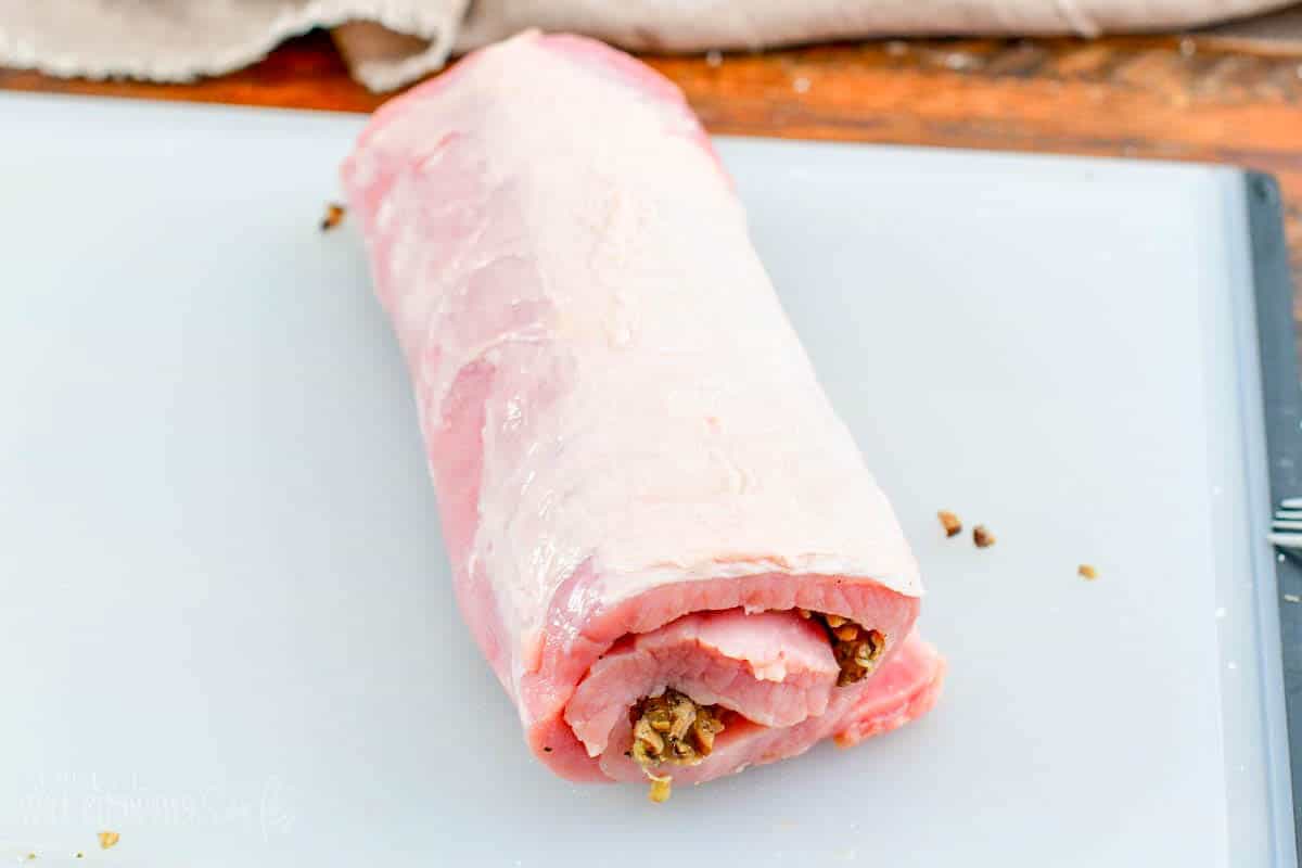 rolled and stuffed pork loin on a cutting board.