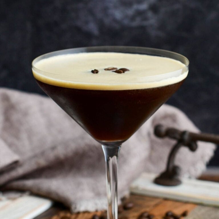 Espresso martini in a glass with espresso beans on top.