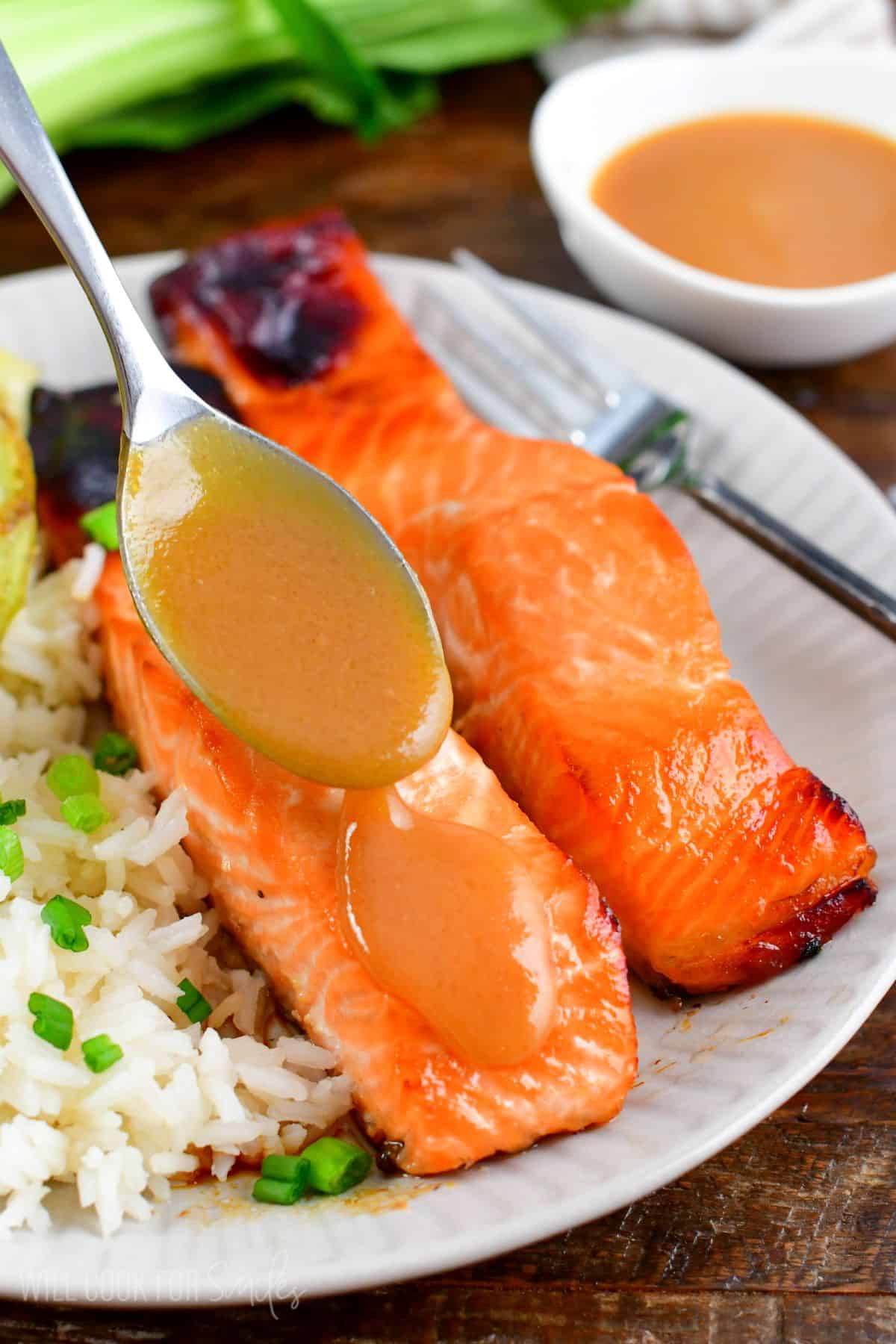 spooning some more miso sauce over baked salmon filet.