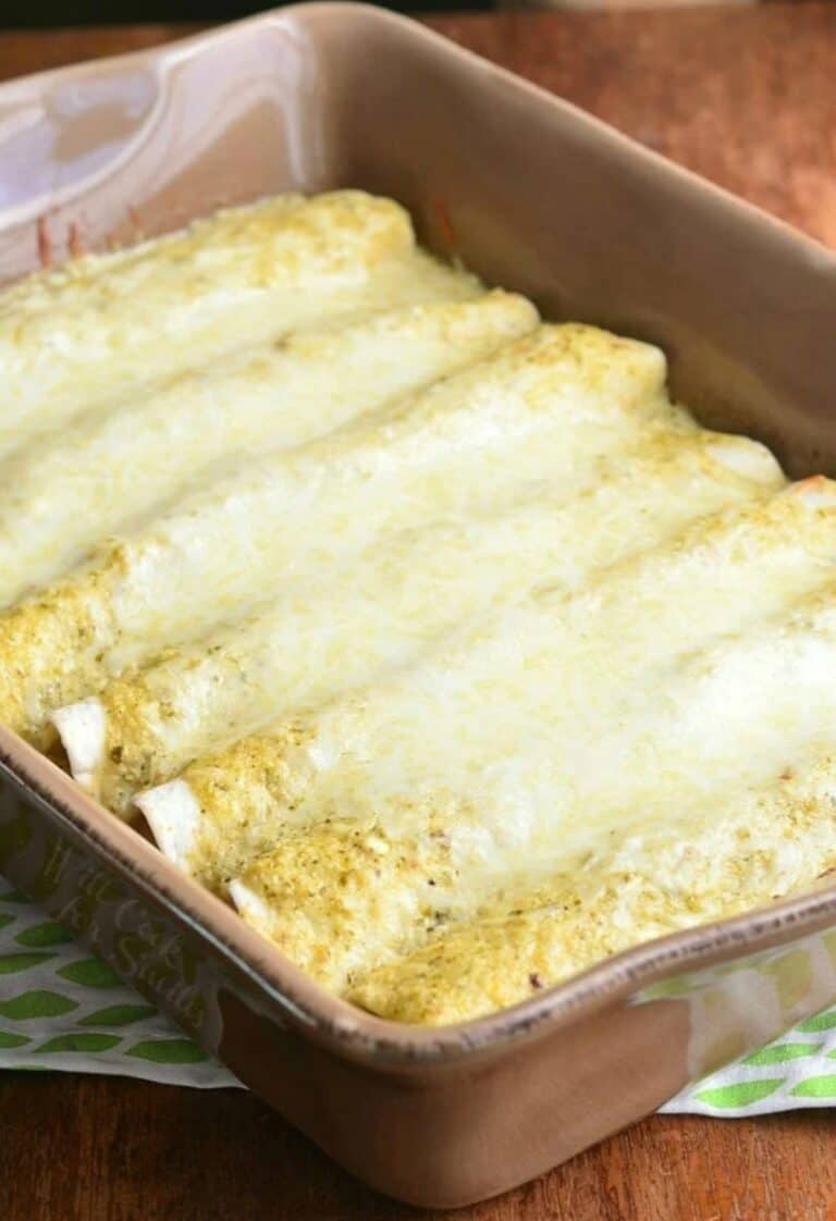 several enchiladas baked in verdes sauce and cheese on top.
