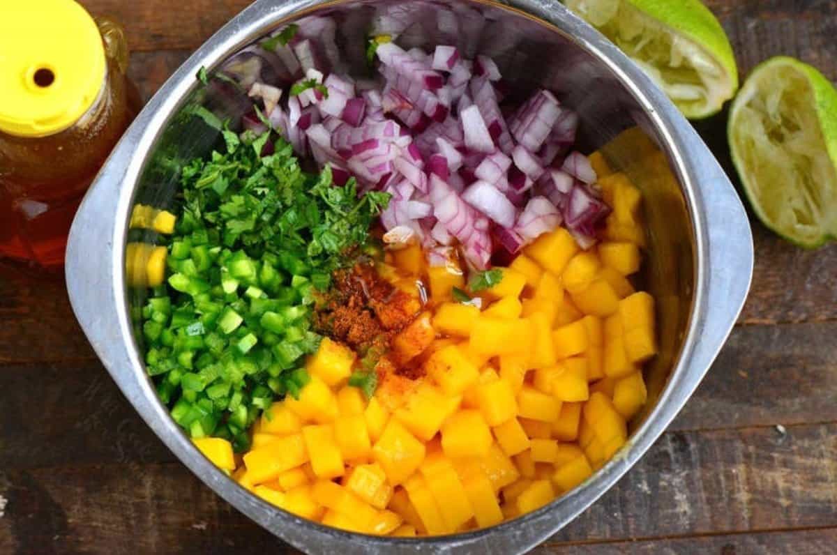 All the ingredients for mango salsa diced up and in a metal bowl.