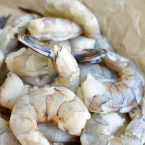 peeled and devievned shrimp laying on parchement paper.