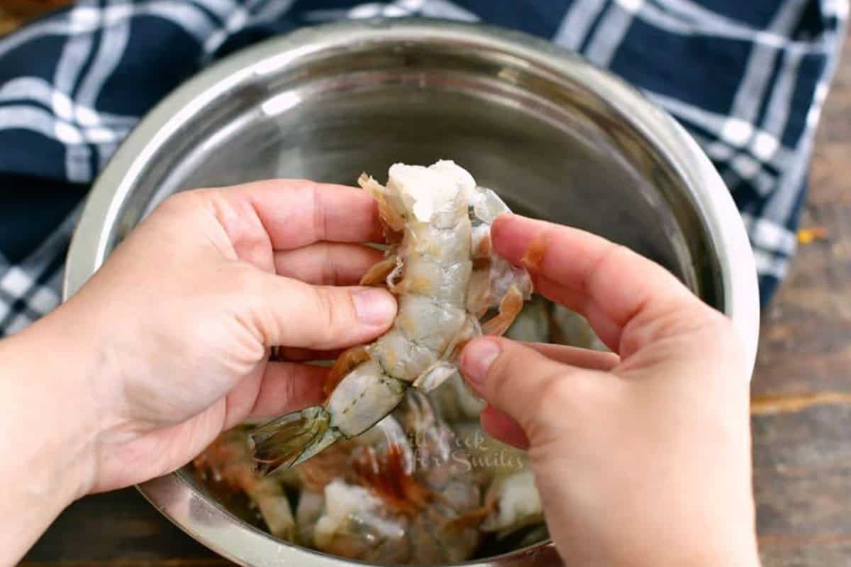 Pulling the shell off of a shrimp.