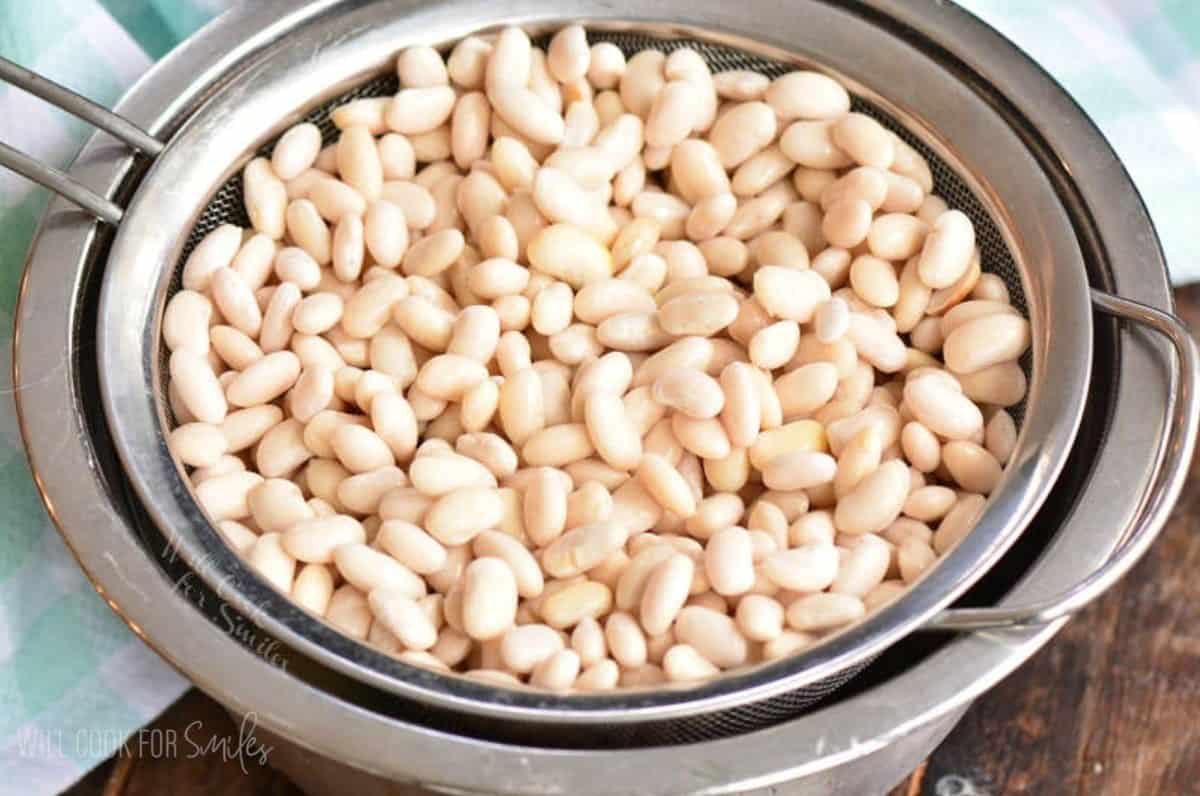 straining soaked white beans in the mesh strainer.
