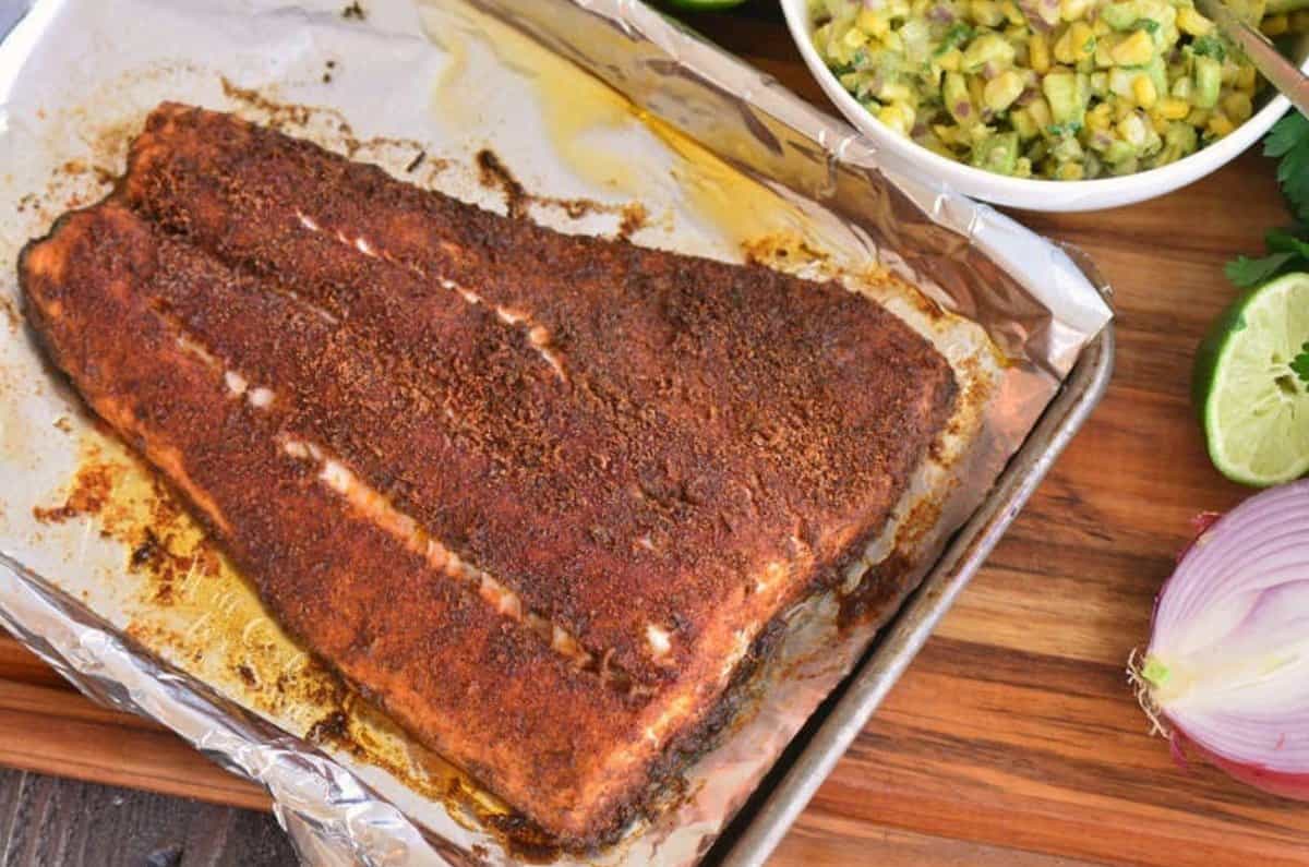 baked seasoned salmon filet on a baking sheet cooked.