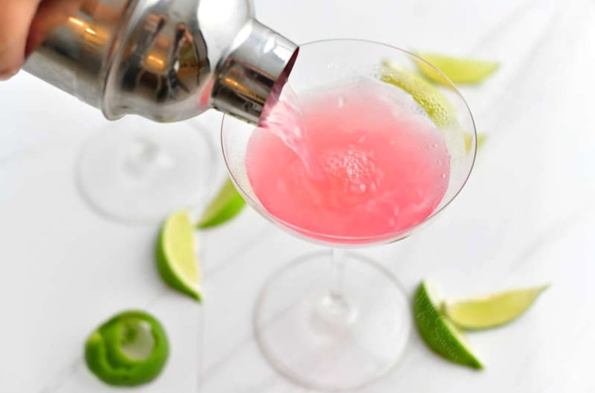 pouring in cosmo martini into the martini glass.