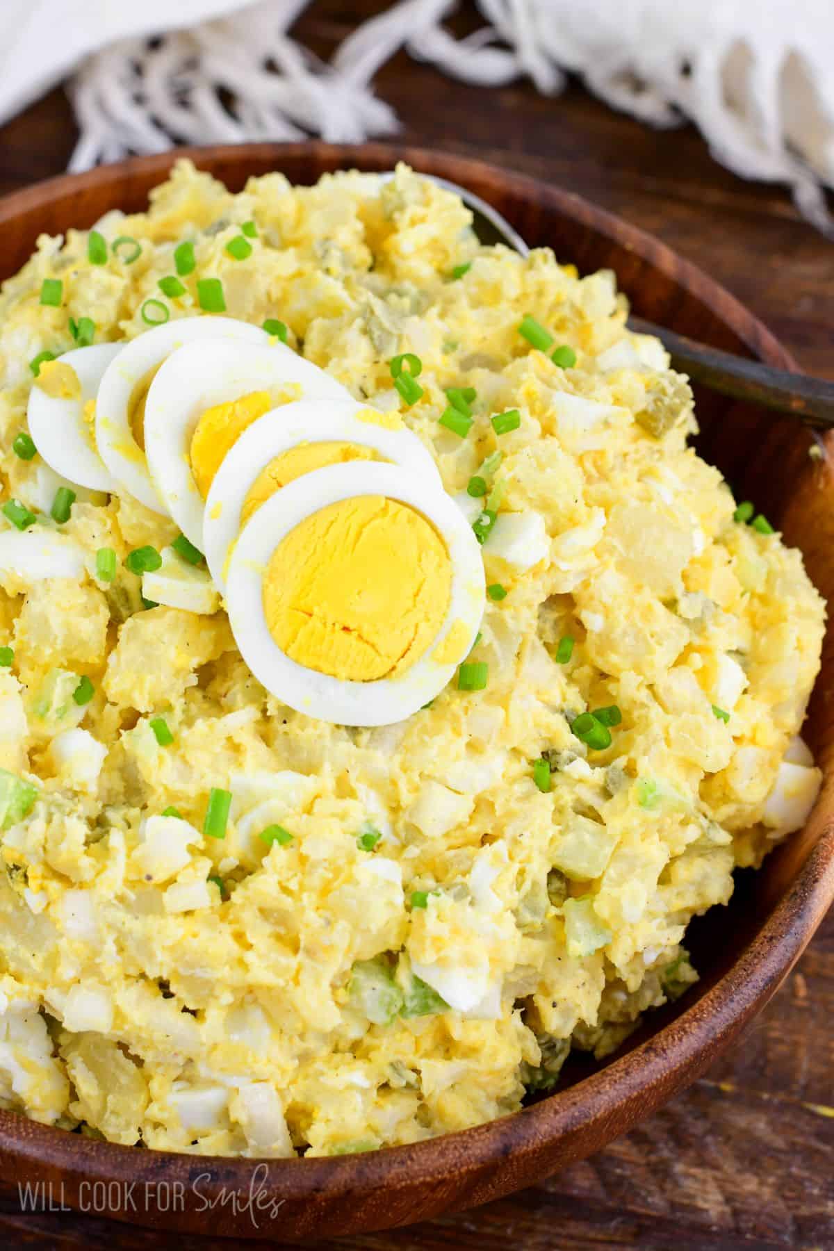 potato salad with eggs, pickles, and creamy mustard sauce in a bowl topped with egg.