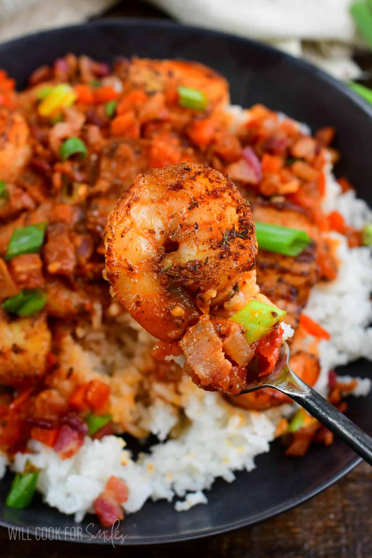 Cajun shrimp and rice in a bowl with a shrimp on a fork.