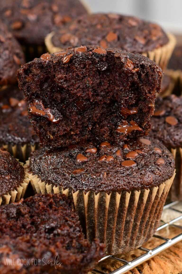 Chocolate zucchini muffins one cut in half on top of a whole muffin.