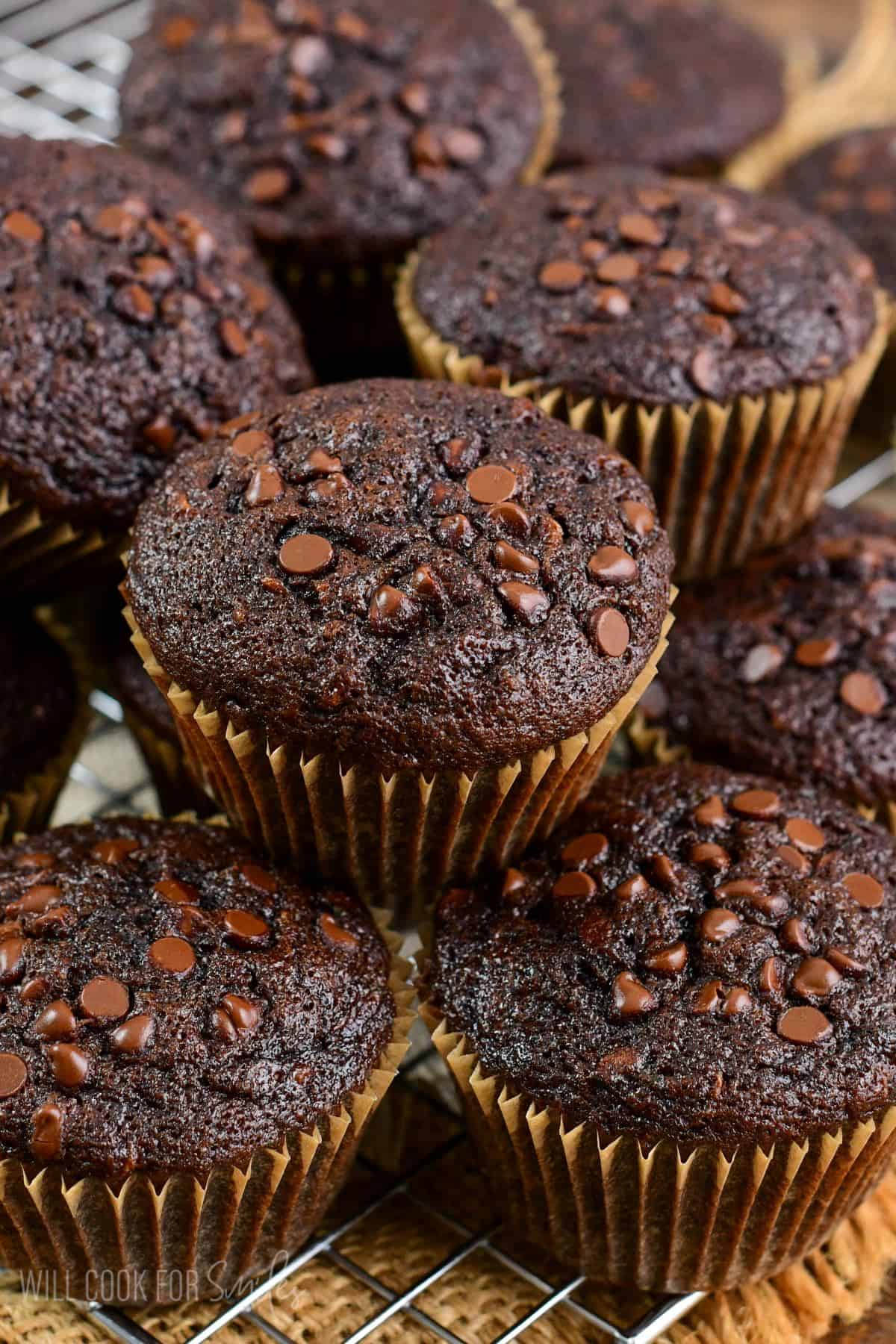 cooked zucchini muffins stacked on a cooling rack.