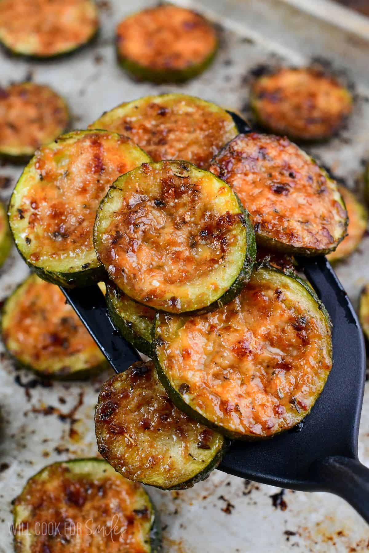 roasted zucchini on a spatula with the rest on a baking sheet.