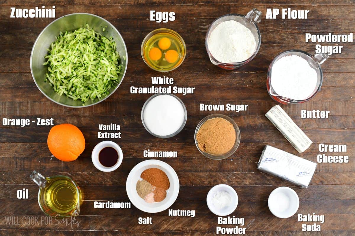 Labeled ingridents for zucchini cake on a wood surface.