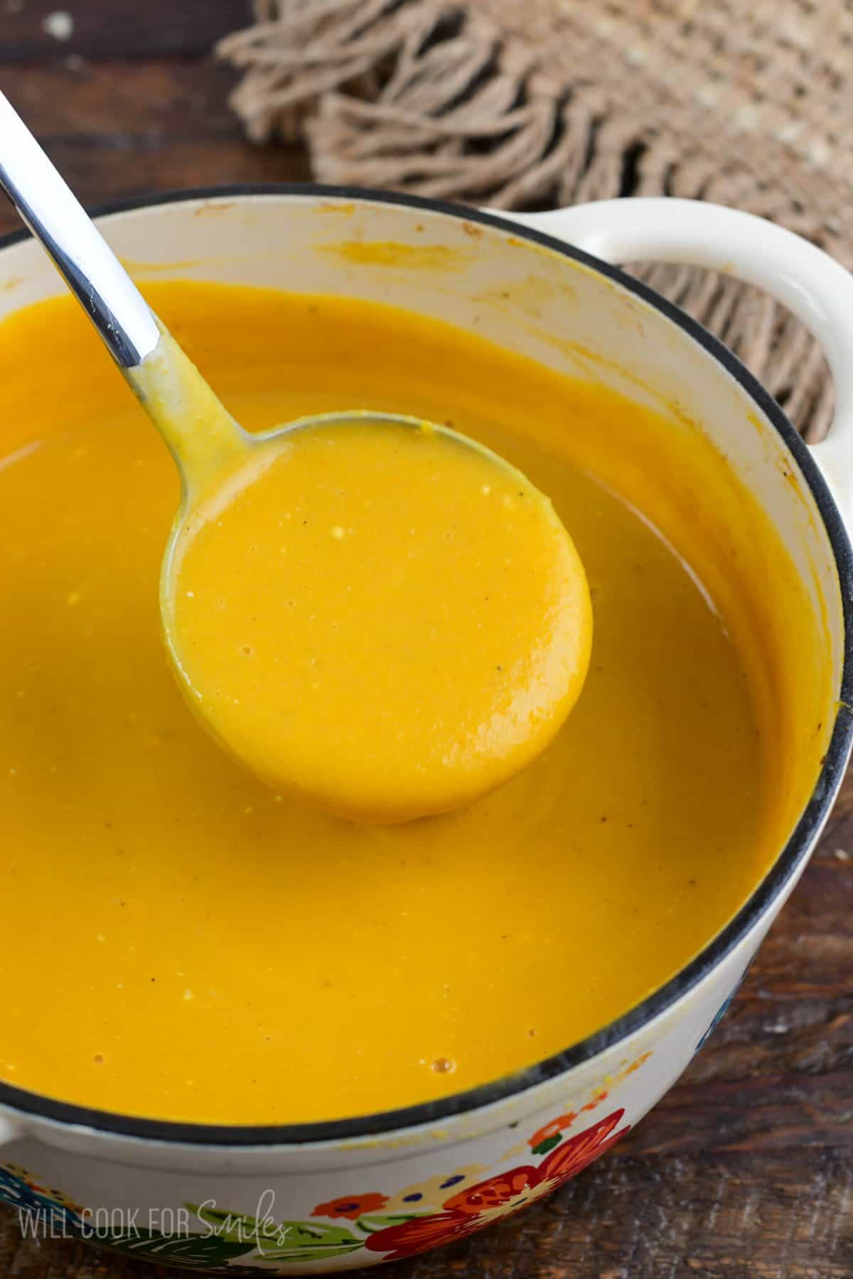 ladling out some Butternut squash potato soup from a flower pot.