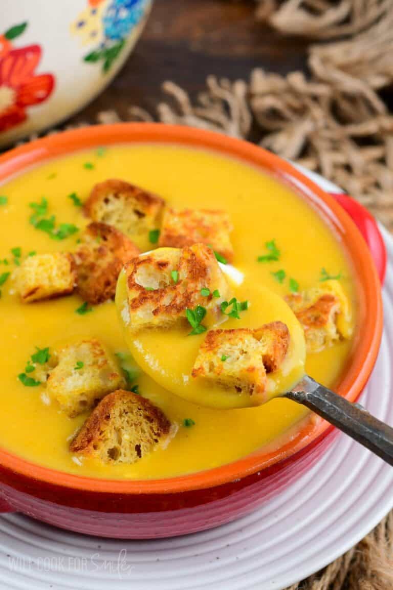 spooning out some Butternut squash potato soup with two croutons as well.