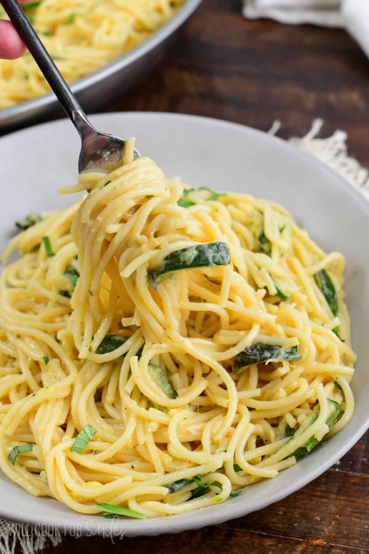 Zucchini pasta in a bowl with a fork with pasta swirled around it.