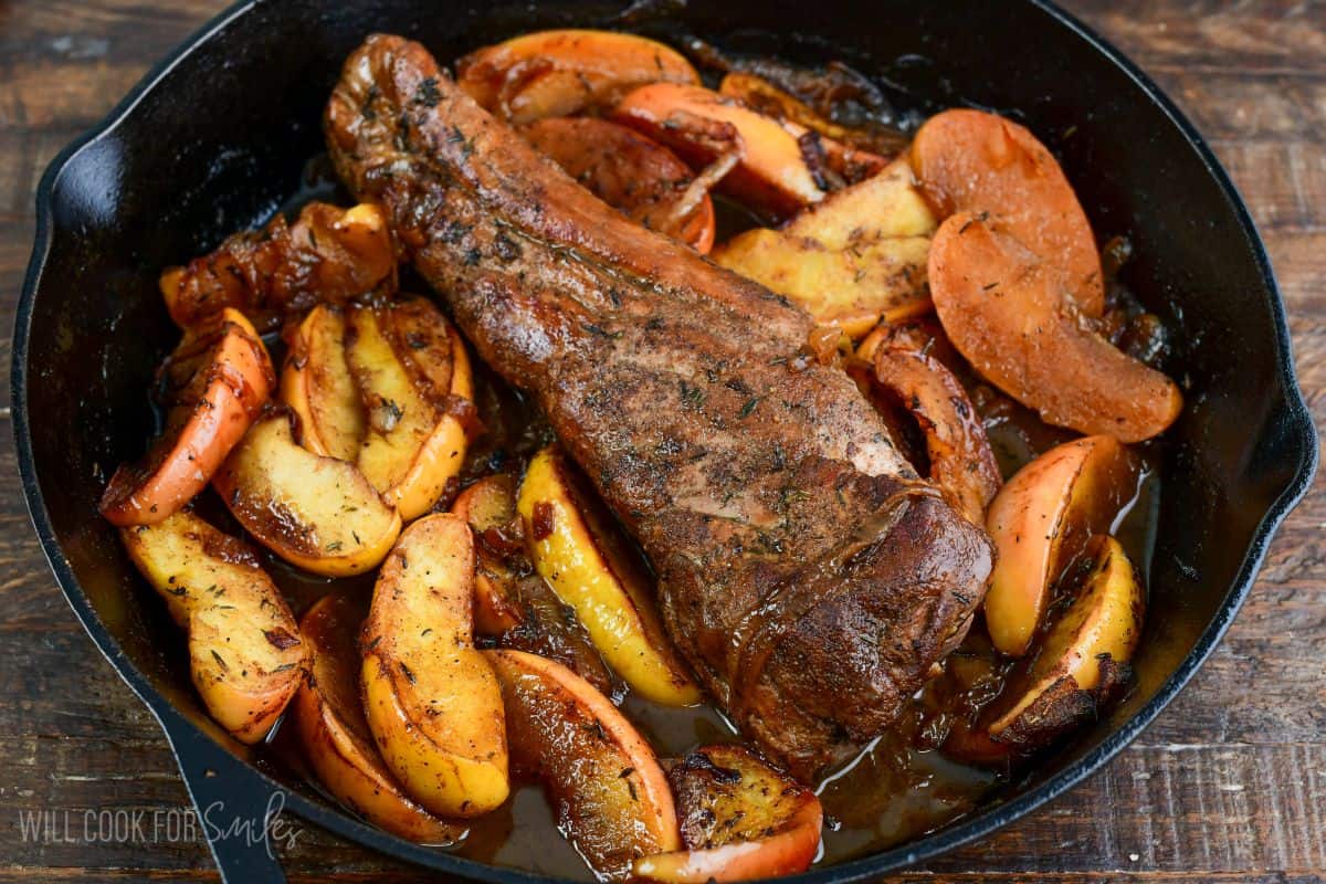 Roasted pork and apples in a cast iron skillet.