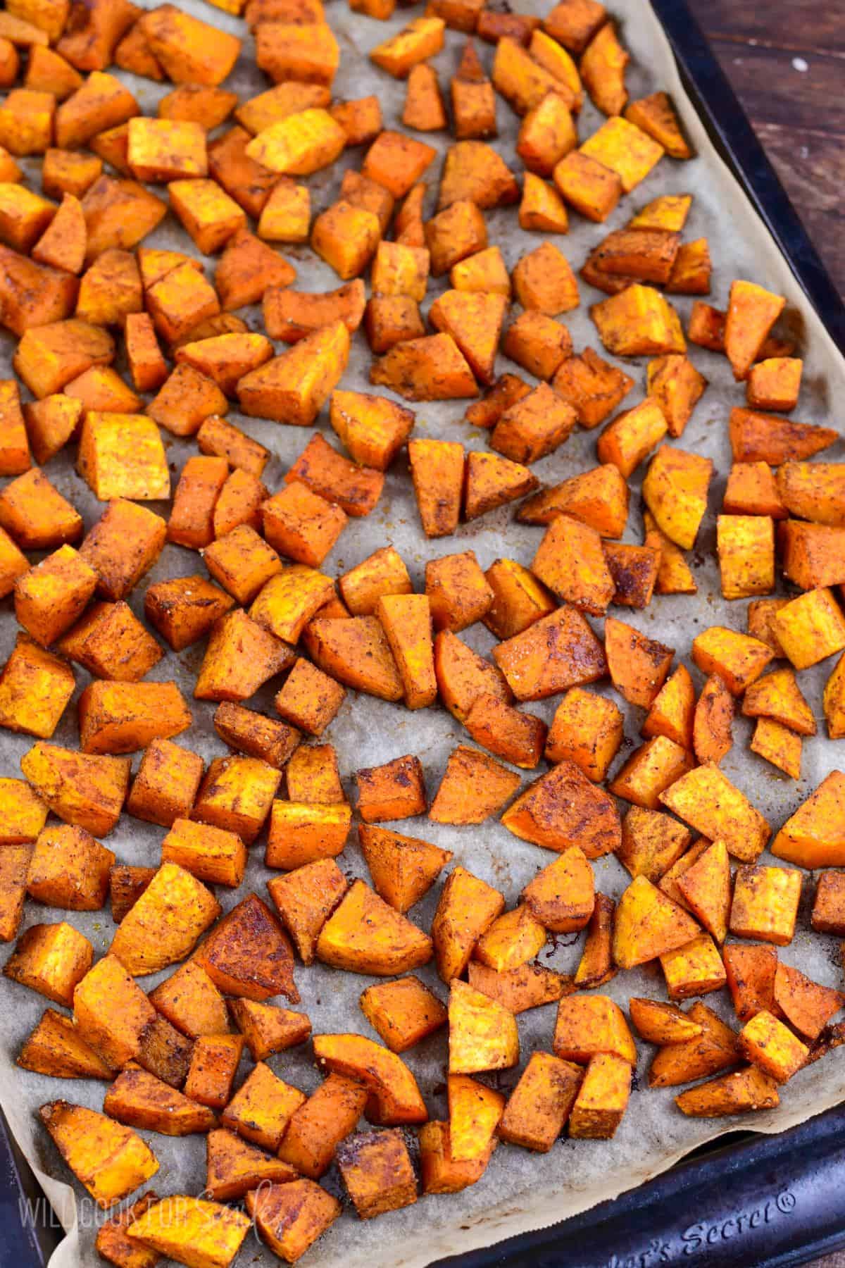 Honeynut squash spread on a parechment paper lined baking sheet.