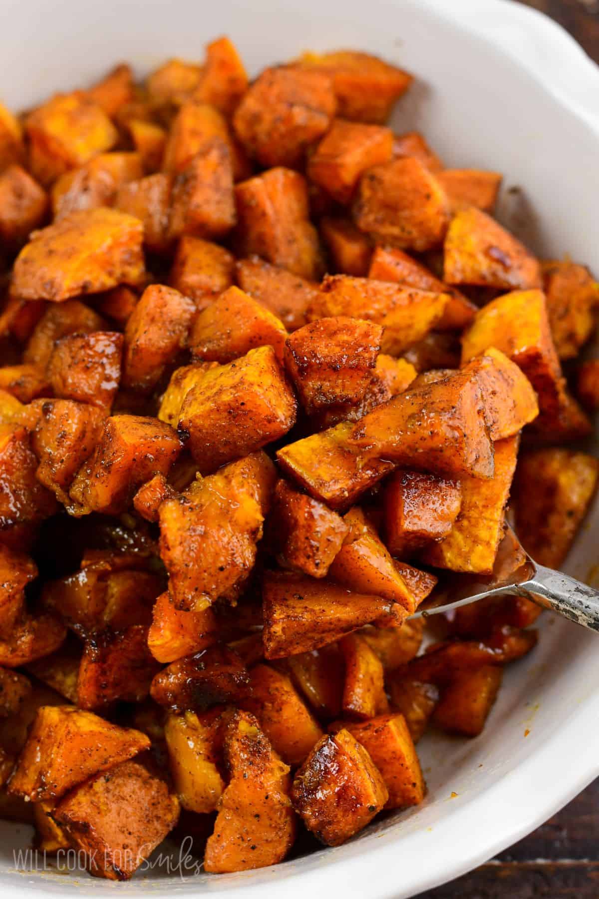 Spiced roasted honeynut sqaush in a bowl with a spoon scooping some out.
