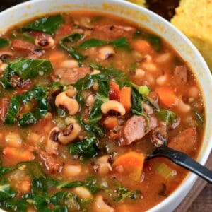 starting to spoon out some Southern black eye pea soup from a bowl next to fresh homemade buttermilk cornbread.