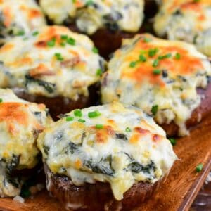 several spinach artichoke stuffed mushrooms with golden melted mozzarella cheese on top.