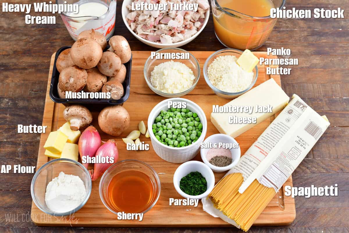 Labeled ingredients for creamy and cheesy Turkey Tetrazzini on a wood surface.