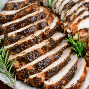 juicy and flavorful turkey tenderloin in a balsamic and Italian seasoning mixture sliced on a platter.