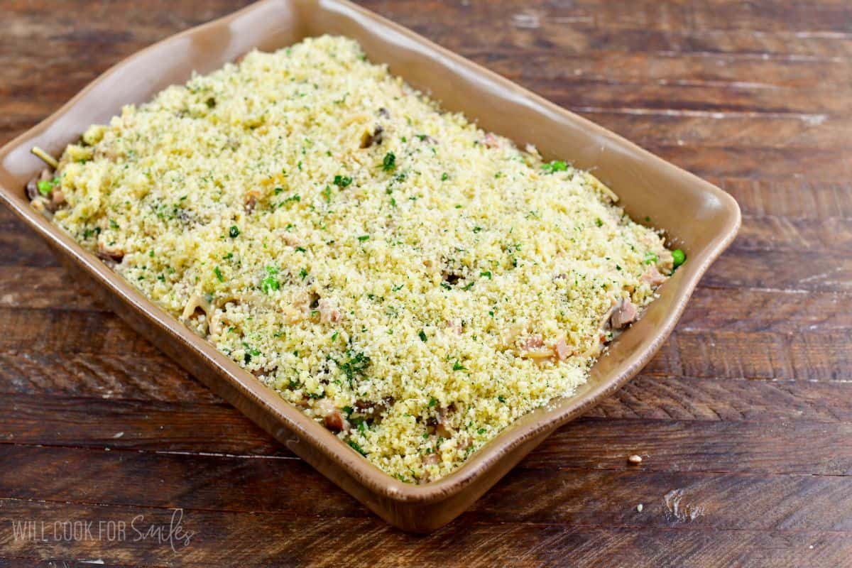 Turkey tetrazzini with bread crumbs on top before baking on a wood surface.
