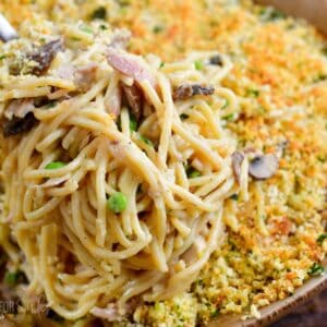 Scooping Turkey Tetrazzini out of casserole dish with a fork.