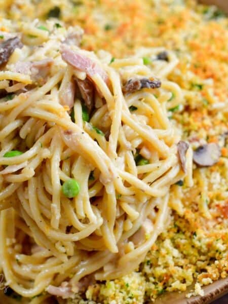 Scooping Turkey Tetrazzini out of casserole dish with a fork.