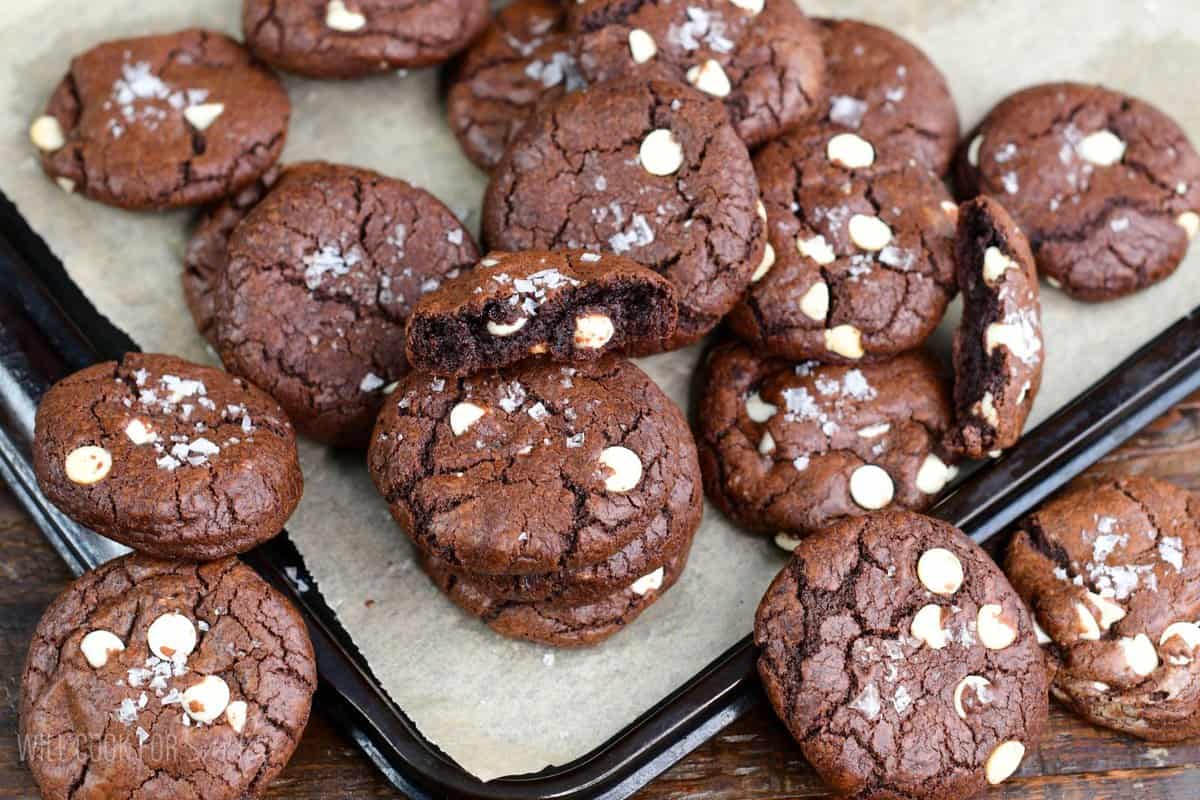 Chocolate brown butter cookies on a parchment lined baking dish.