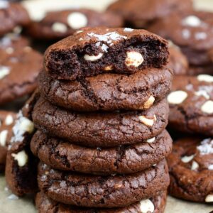Chocolate brown butter cookies stacked up and the top cookie has been broken in half.