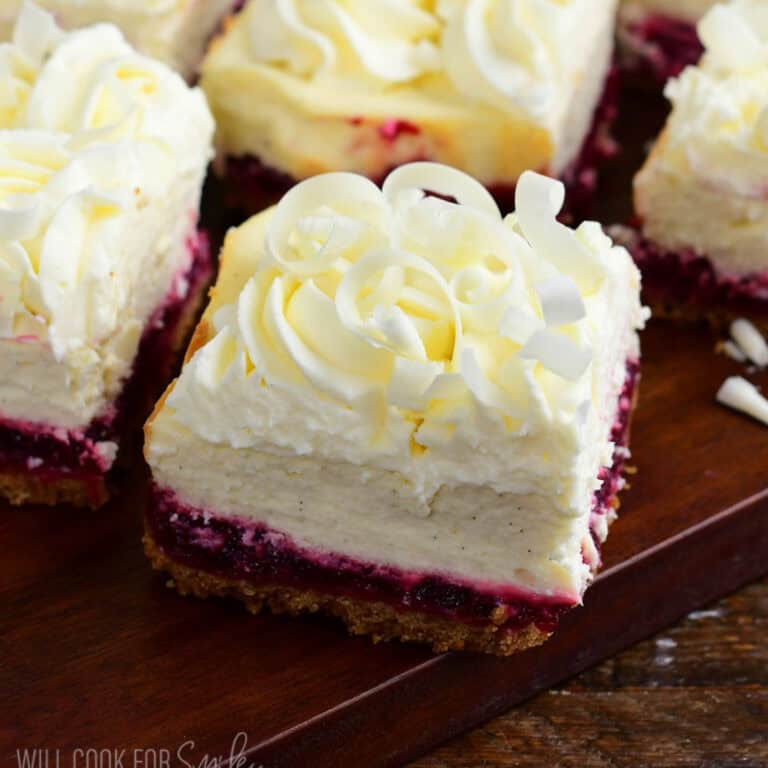 closeup on a square of Christmas cheesecake bar with white chocolate shavings on top.