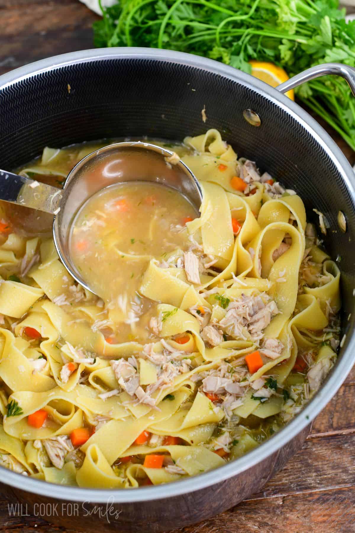Classic chicken noodle soup in a pot made from scratch with vegetables and egg noodles.