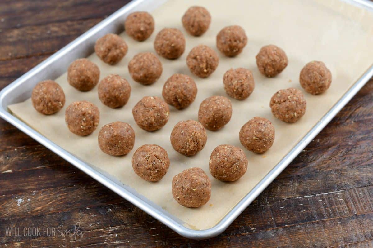 Plan rumchata rum balls on a baking sheet on a wood surface.