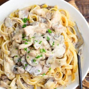 family recipe restaurant style creamy chicken stroganoff over pasta in a bowl.