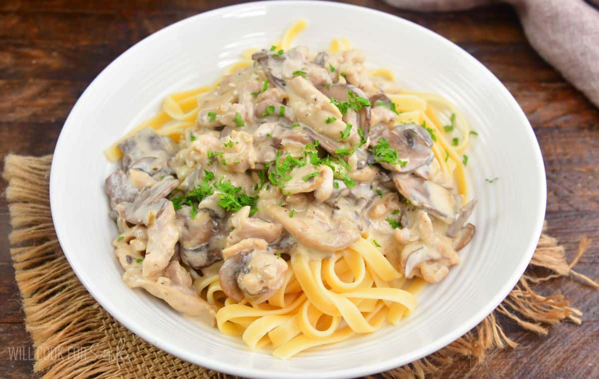 fettuccine topped with creamy restaurant style chicken stroganoff and garnished with parsley.